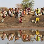 Etat du Nil supérieur, Jamam, camp de réfugiés. L'eau manque cruellement dans ce camp. Les réfugiés forment de longues lignes devant les robinets par 40 degrés. Parfois lorsque leur frustration monte, des bagarres éclatent.
Upper Nile State, Jamam, refugee camp. Water is desperately scarce in this camp and people form long lines at taps in 40 degrees of heat. Frustration mounts and fights sometimes break out.
ICRC website, Photo gallery, 16-05-2012
South Sudan: struggling for survival as conflict intensifies
People living in the border region between South Sudan and Sudan are struggling to survive in an area gripped by armed violence that continues to escalate. Getty photographer Tom Stoddart captures their struggle and the ICRC's efforts to help them.
The Jamam refugee camp in Upper Nile State houses 36,500 vulnerable people who have fled across the border from their homes in Blue Nile state to escape the ongoing fighting in the border region.
Nearby at a dried up watering hole, every day dozens of thirsty children dig deep holes and caves into the parched earth to scoop up cups of muddy water.
Sarah Yabura aged 16 says "Getting water from the holes is very dangerous. I'm afraidof the snakes. Life here is difficult and it will get much worse during the rainy season because this area will be flooded. Our whole family is here except my grandmother who stayed in Blue NIle. I have no hope for the future because there is no school here, no good life and my future is dark". 
People are weakened by vomiting and diarrhoea but NGO's believe the real danger will come when the rains arrive in a few weeks time. 
Marcel Pelletier, a water engineer with the ICRC says, "In my ten years' expreience as a water engineer in conflict-affected areas, I wouls say the water shortage in Jamam is as severe as anything I've seen. It is a desperate situation. There is no excess water for washing; it is all used for cooking and drinking. Peolple are digging by hand into the ground on the site of dried-up watering holes and scooping up any water they find. These people are thirsty and are spending six hours outside with jerry cans in the intense heat. The rains will come in about 5 weeks. Far from being the solution, the rains will actually make things worse. The lowland where animals now gaze and which people used as a toilet will flood, turning it into a vast contaminated lake. With no clean water nearby, people will drink directly from it. The health risk is glaring; deadly water-related diseases couls sweep through the camp like wildfire. We have a real humanitarian crisis on our hands. We only have weeks to prevent it getting worse and indeed spinnin out of control."