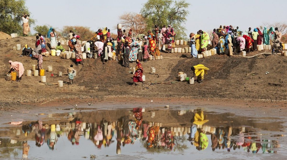 Etat du Nil supérieur, Jamam, camp de réfugiés. L'eau manque cruellement dans ce camp. Les réfugiés forment de longues lignes devant les robinets par 40 degrés. Parfois lorsque leur frustration monte, des bagarres éclatent.
Upper Nile State, Jamam, refugee camp. Water is desperately scarce in this camp and people form long lines at taps in 40 degrees of heat. Frustration mounts and fights sometimes break out.
ICRC website, Photo gallery, 16-05-2012

South Sudan: struggling for survival as conflict intensifies

People living in the border region between South Sudan and Sudan are struggling to survive in an area gripped by armed violence that continues to escalate. Getty photographer Tom Stoddart captures their struggle and the ICRC's efforts to help them.

The Jamam refugee camp in Upper Nile State houses 36,500 vulnerable people who have fled across the border from their homes in Blue Nile state to escape the ongoing fighting in the border region.

Nearby at a dried up watering hole, every day dozens of thirsty children dig deep holes and caves into the parched earth to scoop up cups of muddy water.

Sarah Yabura aged 16 says "Getting water from the holes is very dangerous. I'm afraidof the snakes. Life here is difficult and it will get much worse during the rainy season because this area will be flooded. Our whole family is here except my grandmother who stayed in Blue NIle. I have no hope for the future because there is no school here, no good life and my future is dark". 
People are weakened by vomiting and diarrhoea but NGO's believe the real danger will come when the rains arrive in a few weeks time. 
Marcel Pelletier, a water engineer with the ICRC says, "In my ten years' expreience as a water engineer in conflict-affected areas, I wouls say the water shortage in Jamam is as severe as anything I've seen. It is a desperate situation. There is no excess water for washing; it is all used for cooking and drinking. Peolple are digging by hand into the ground on the site of dried-up watering holes and scooping up any water they find. These people are thirsty and are spending six hours outside with jerry cans in the intense heat. The rains will come in about 5 weeks. Far from being the solution, the rains will actually make things worse. The lowland where animals now gaze and which people used as a toilet will flood, turning it into a vast contaminated lake. With no clean water nearby, people will drink directly from it. The health risk is glaring; deadly water-related diseases couls sweep through the camp like wildfire. We have a real humanitarian crisis on our hands. We only have weeks to prevent it getting worse and indeed spinnin out of control."