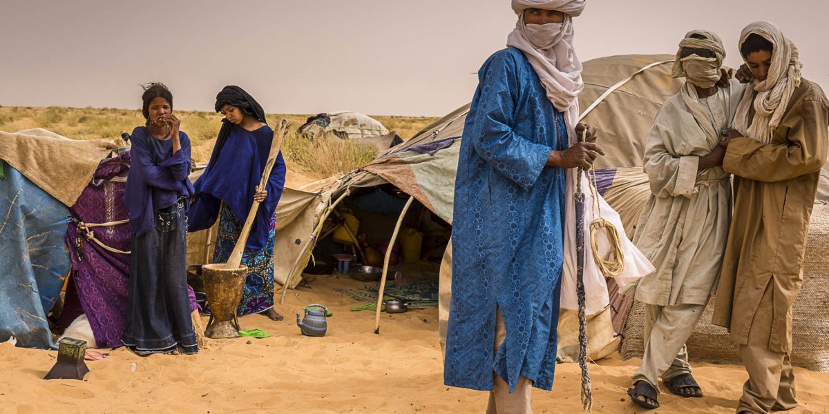 A Tuareg family after having returned to their ehan, the circular tent they live in, complete their activities before night fall in theTénéré region - Tchirozerine, north central Niger.